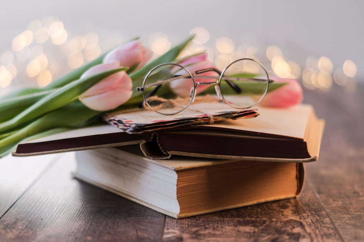 Glasses and flowers on a couple of books